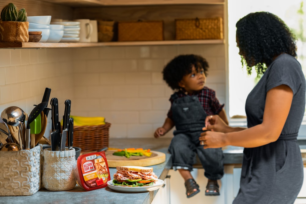 boy in black and gray stripe polo shirt standing in front of table