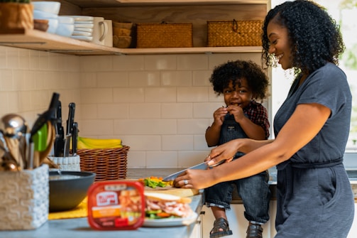 A smiling woman preparing a nutritious meal with her child.