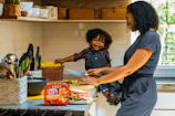 A busy mom chopping vegetables quickly with a smile.