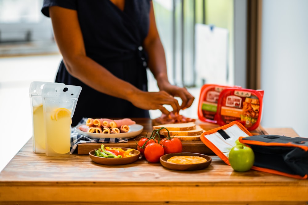 man in black polo shirt standing beside table with food