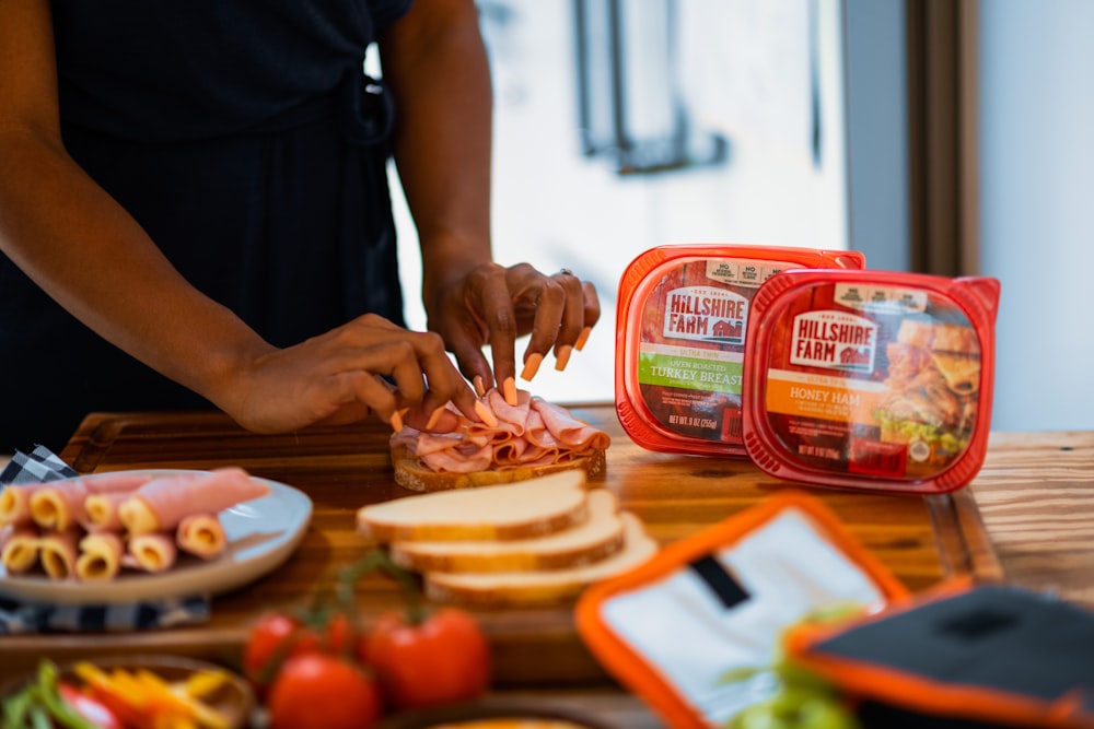 person holding red and white plastic container