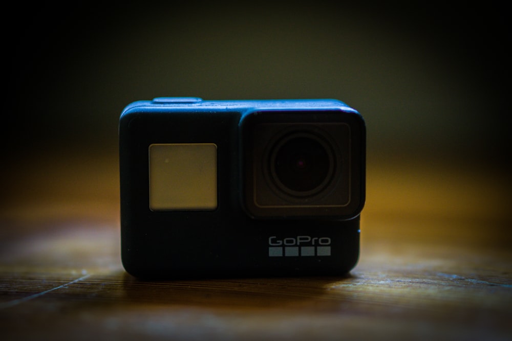 black and blue camera on brown wooden table