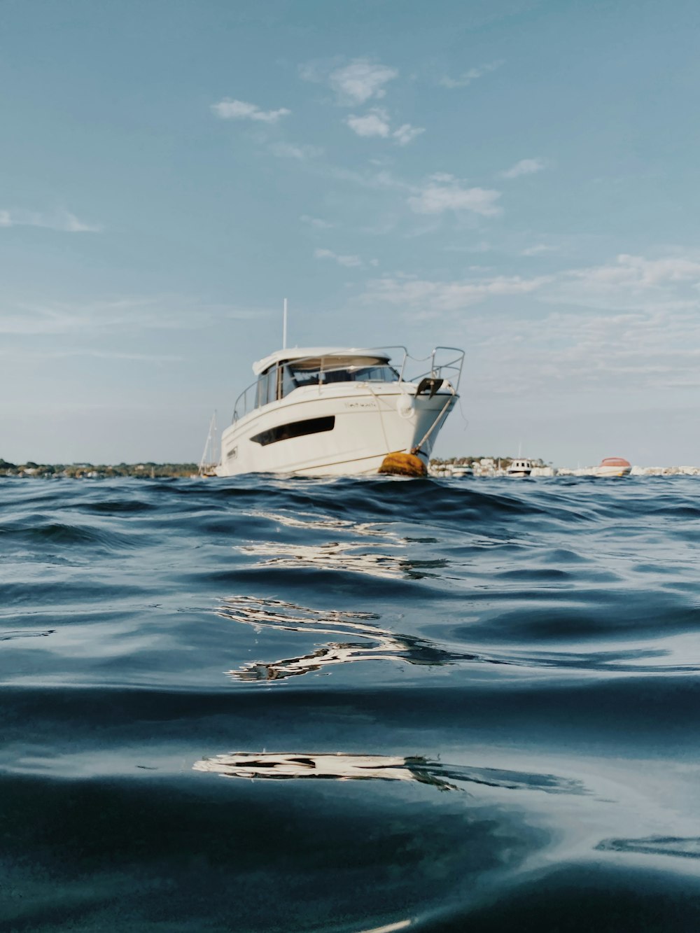 Barca bianca e gialla sul mare sotto il cielo blu durante il giorno