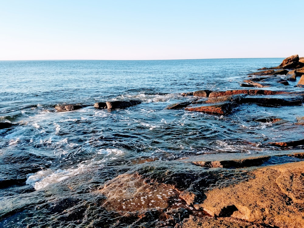 brown rocky shore under blue sky during daytime