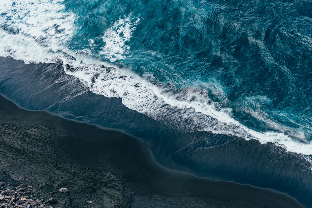 ocean waves crashing on shore during daytime