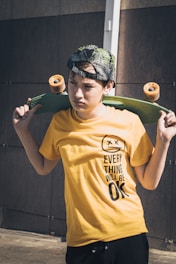man in yellow crew neck t-shirt holding green tennis racket