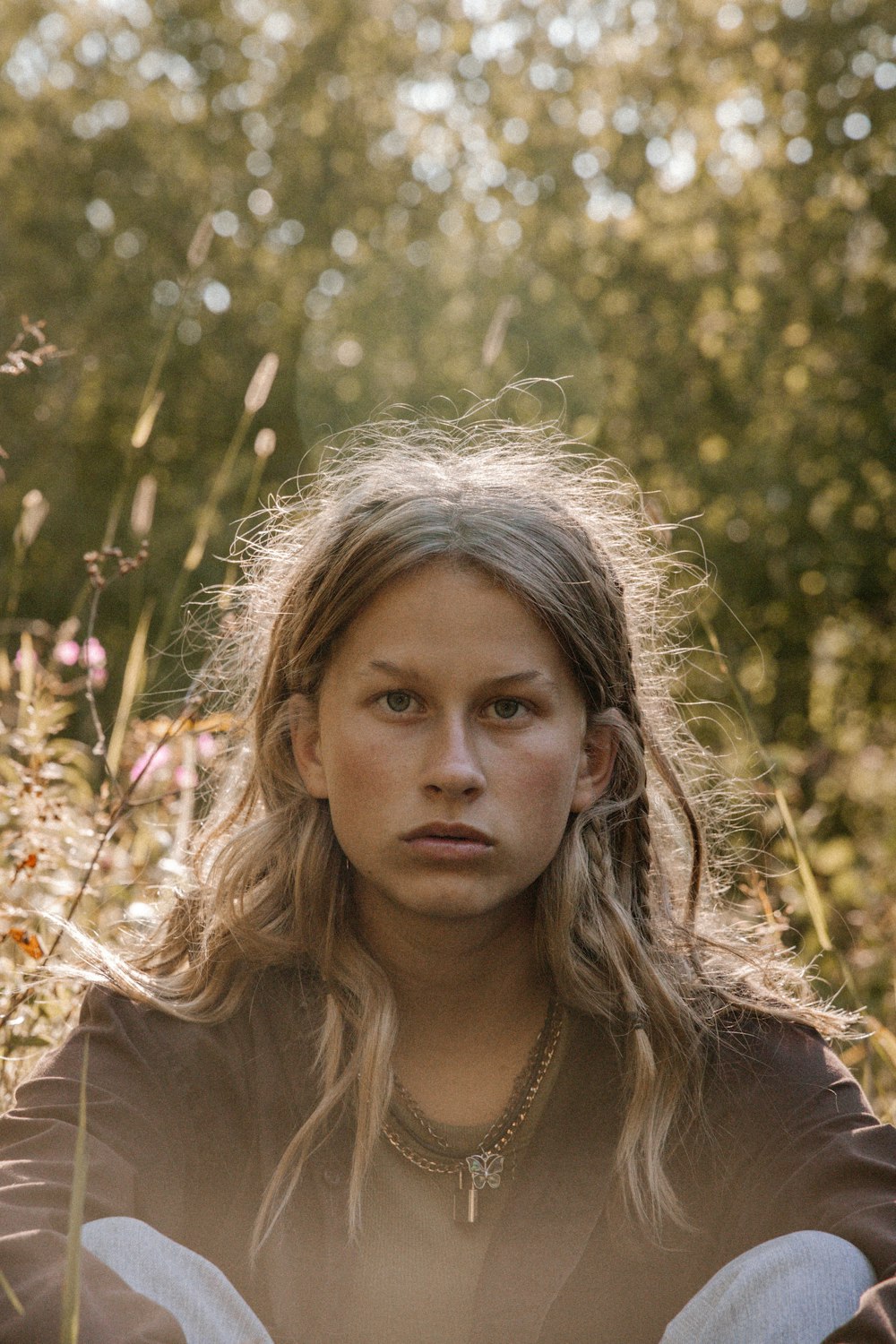 woman in brown shirt standing near green plants during daytime