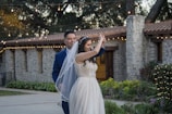 Candid moment of guests dancing joyfully under twinkling string lights.
