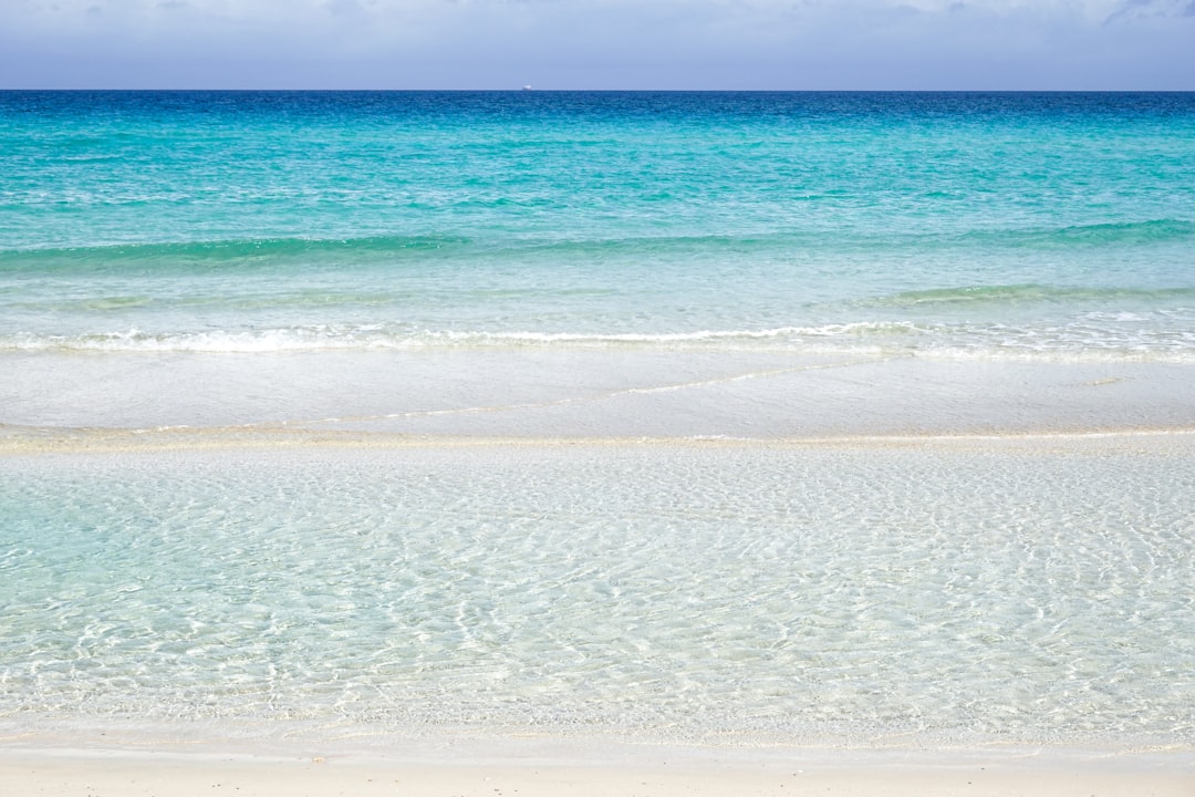 blue sea waves on white sand beach during daytime