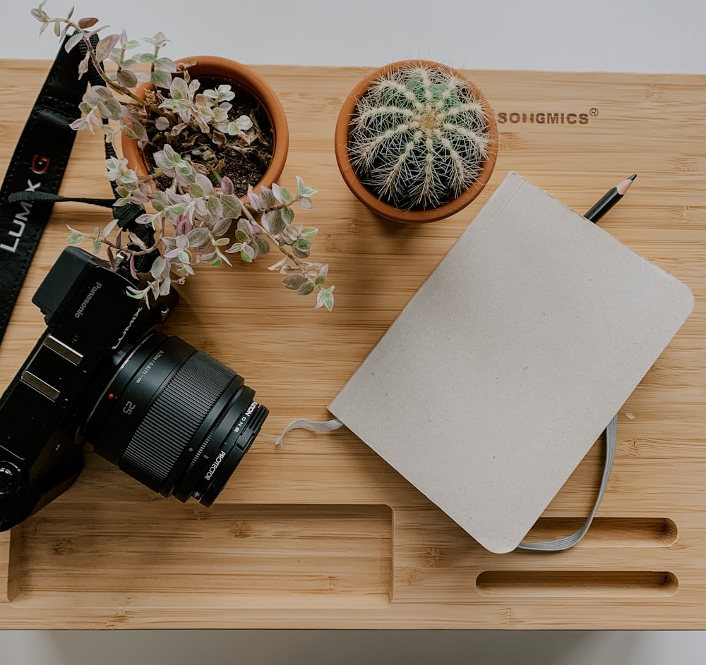 black dslr camera on brown wooden table