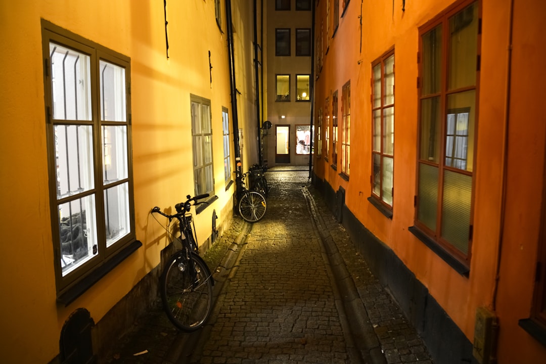 black bicycle parked beside yellow painted building