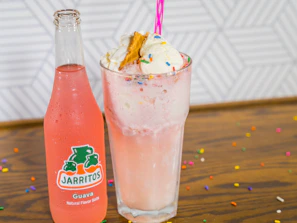 Close-up of a colorful dirty soda topped with whipped cream and a straw, styled with retro desert colors.