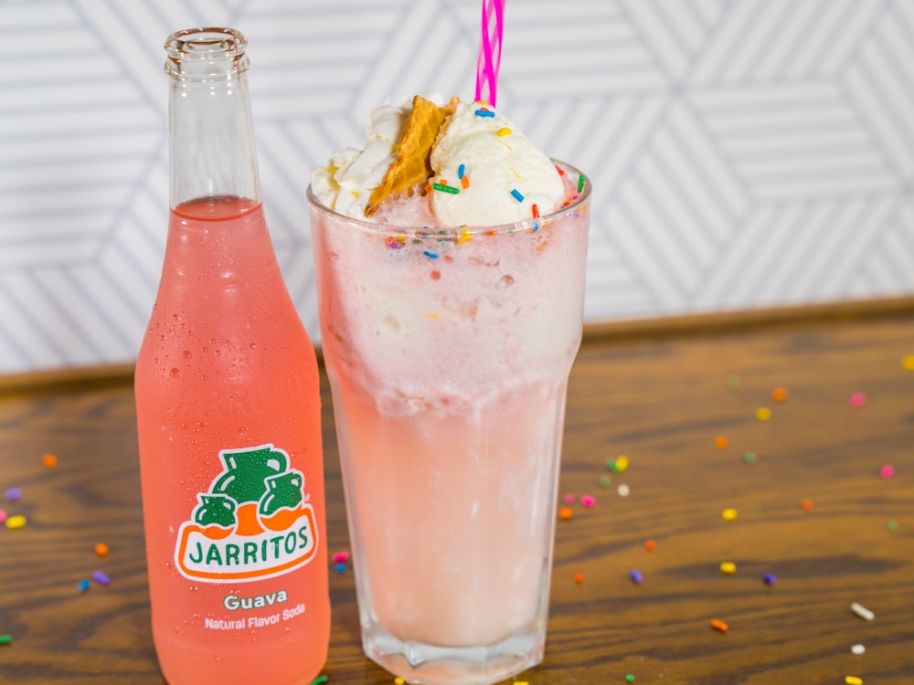 clear drinking glass with ice cream and straw