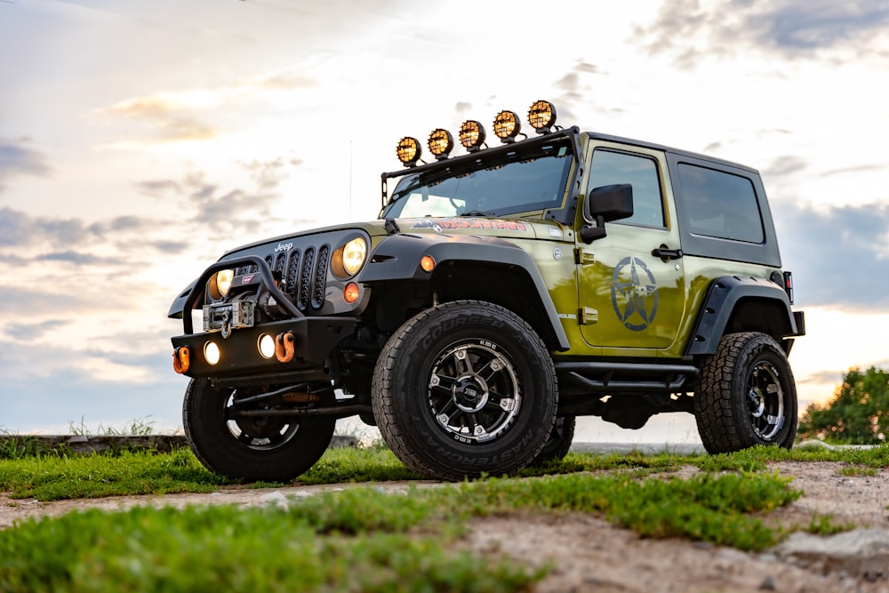 green and black jeep wrangler on green grass field during daytime