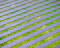 An array of solar panels arranged in parallel rows on a lush green field, capturing sunlight for energy conversion. The solar panels create a pattern of alternating blue and green stripes.