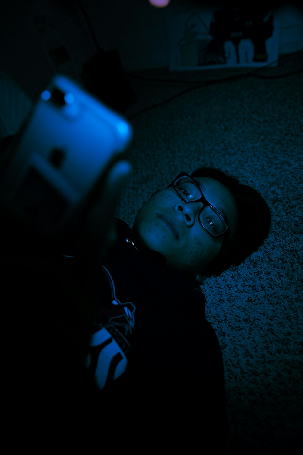 boy in black framed eyeglasses lying on floor