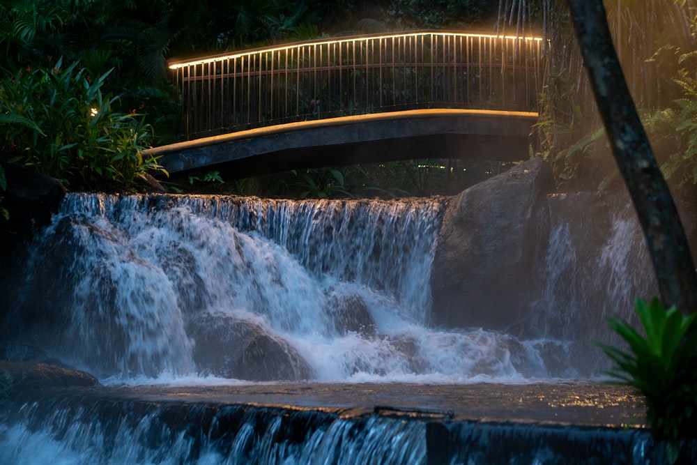 El agua cae debajo del puente de madera marrón durante el día