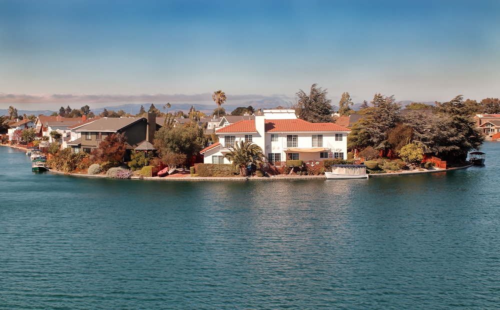 white and brown concrete house near body of water during daytime