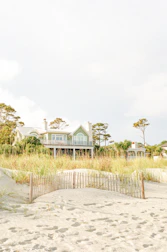 white and green wooden house surrounded by green grass field under white sky during daytime