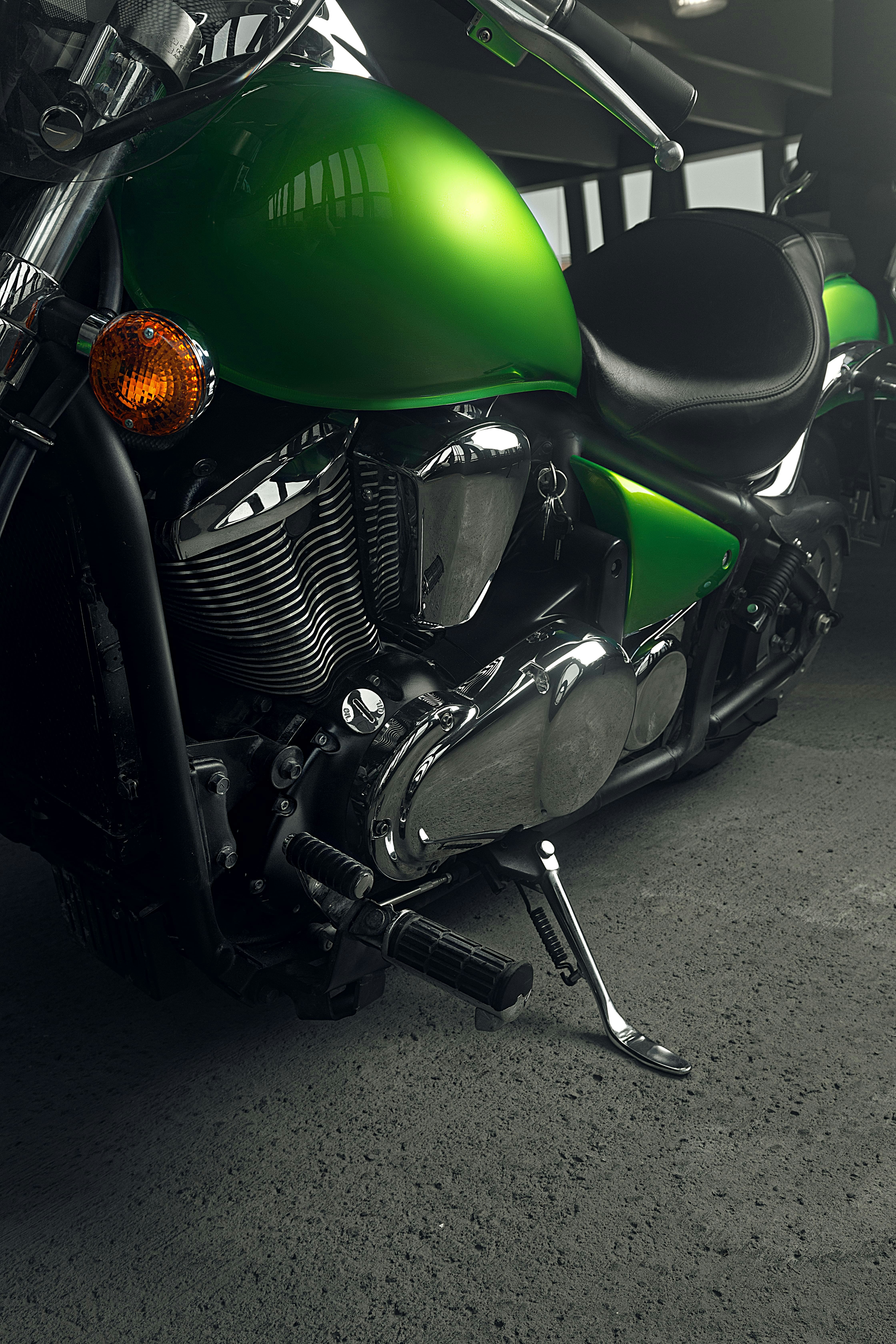 green and black motorcycle on gray concrete floor