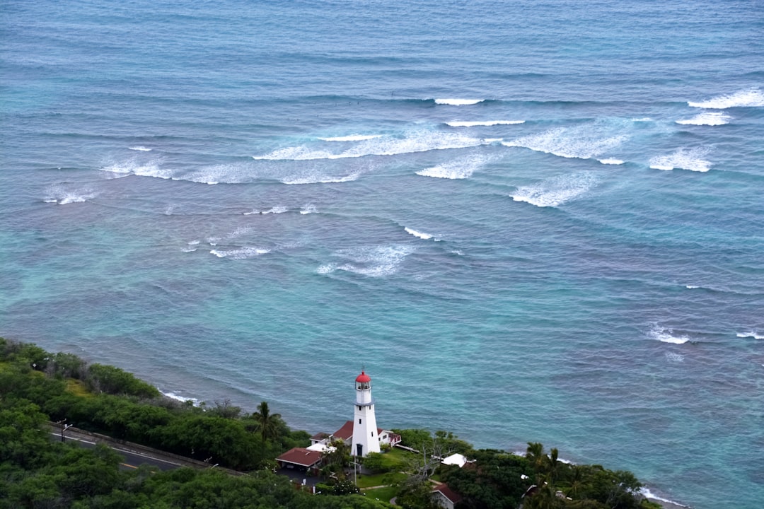 white and red lighthouse near body of water during daytime