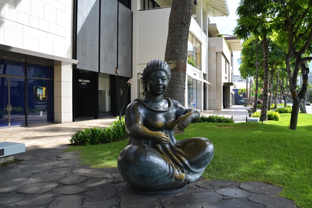 gray concrete statue near white building during daytime