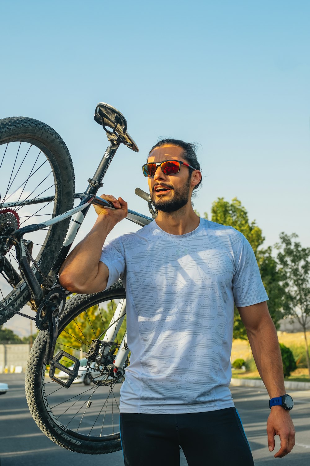 man in white crew neck t-shirt riding black bicycle during daytime