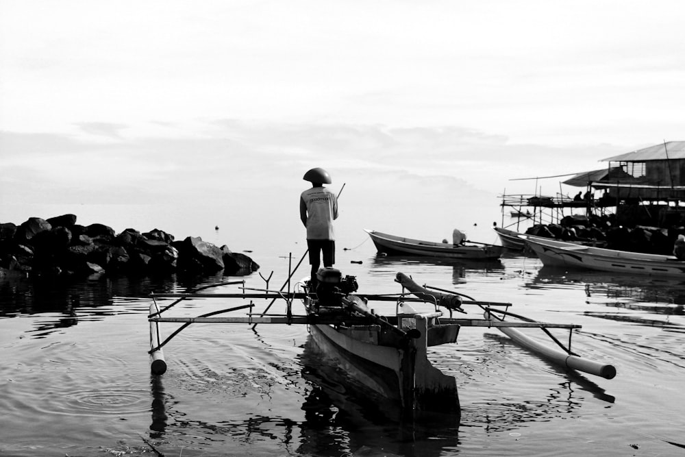 man in white t-shirt standing on white boat during daytime