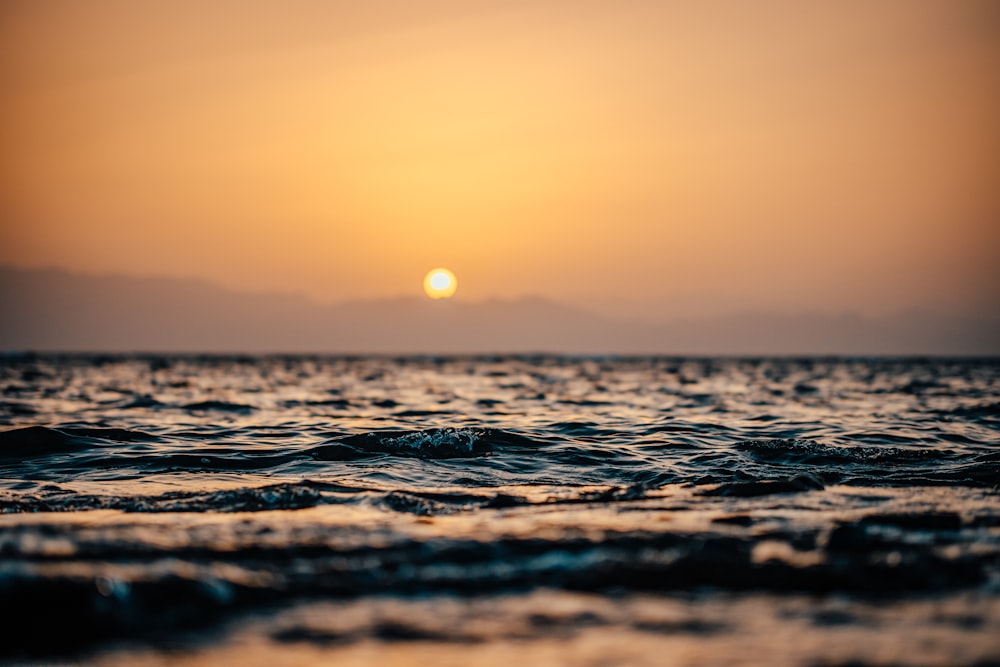 ocean waves under orange sunset