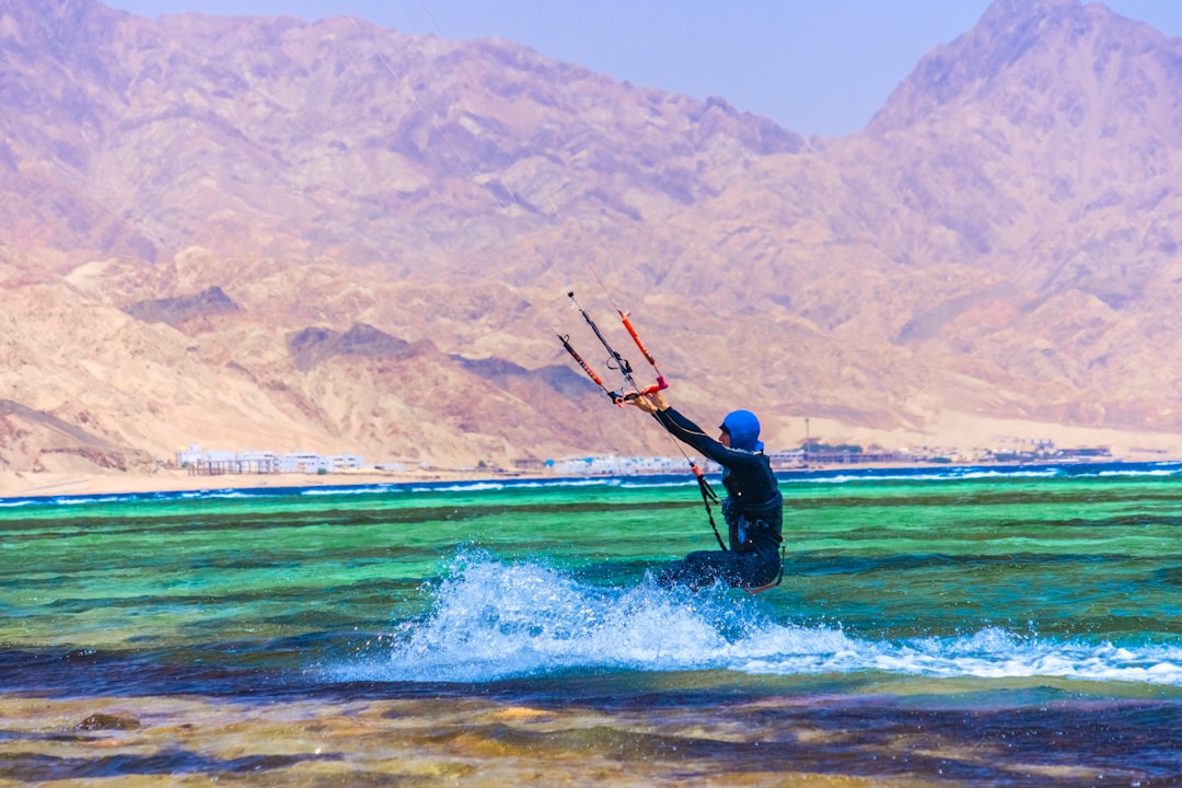 man in black wet suit riding on surfboard during daytime