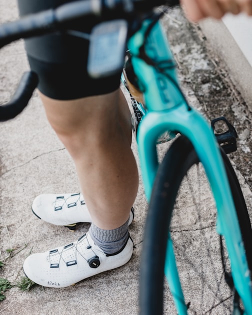 Detalhe em ângulo baixo do pé e da sapatilha de um ciclista sobre o pedal durante a pedalada