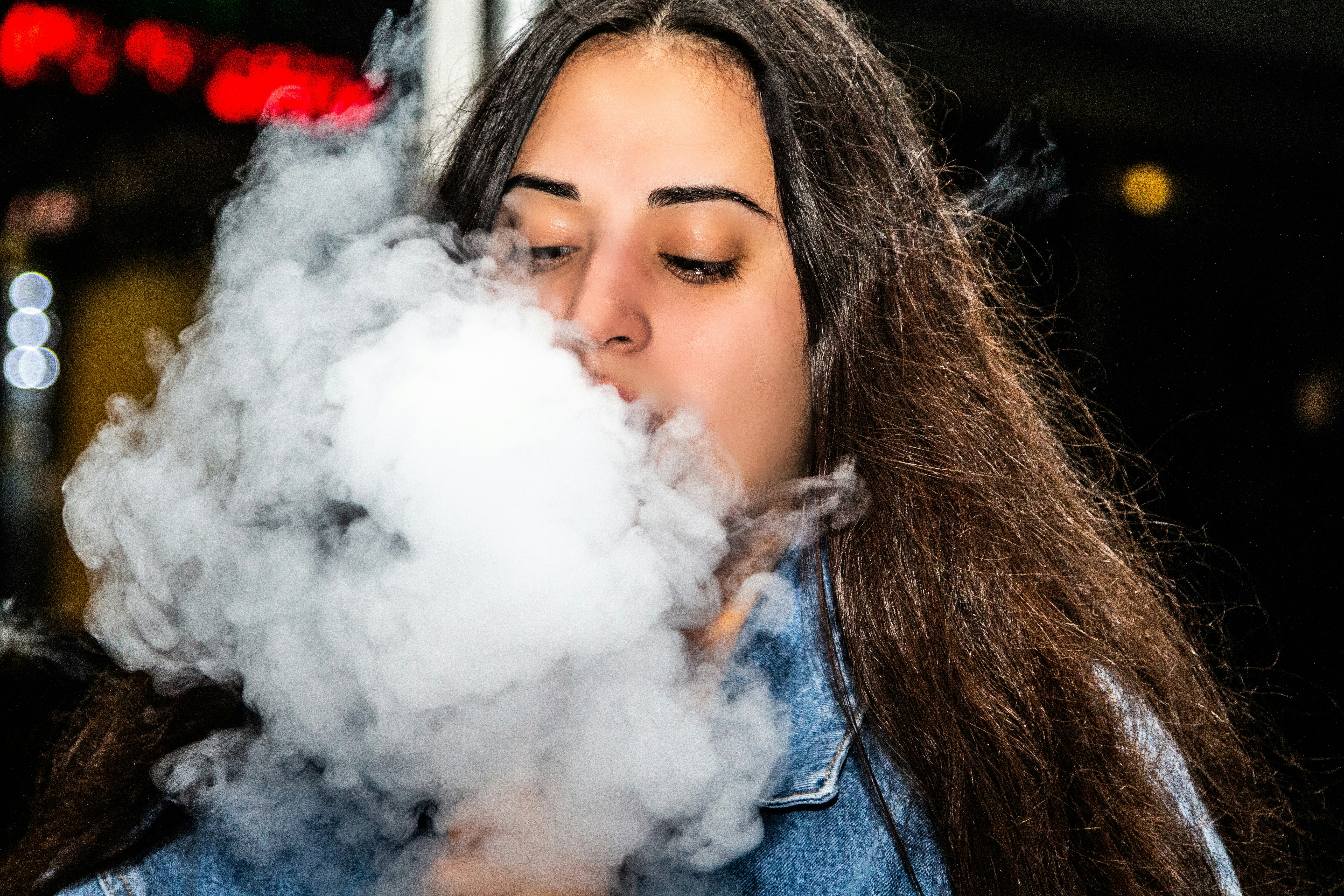 woman in blue denim jacket smoking