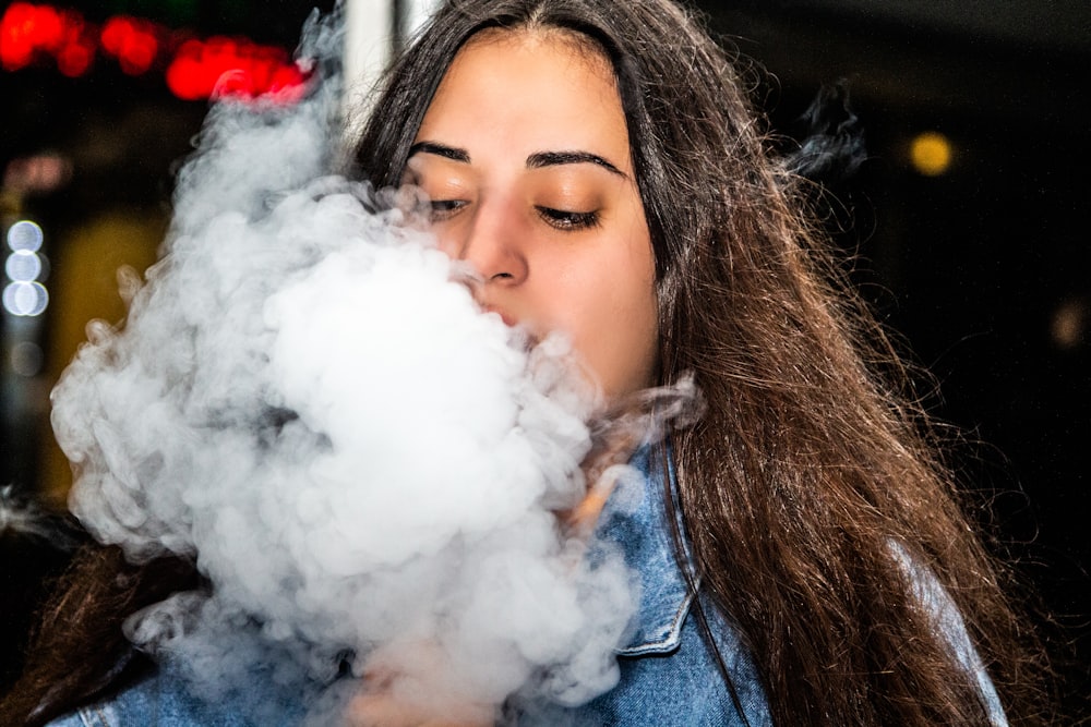 woman in blue denim jacket smoking