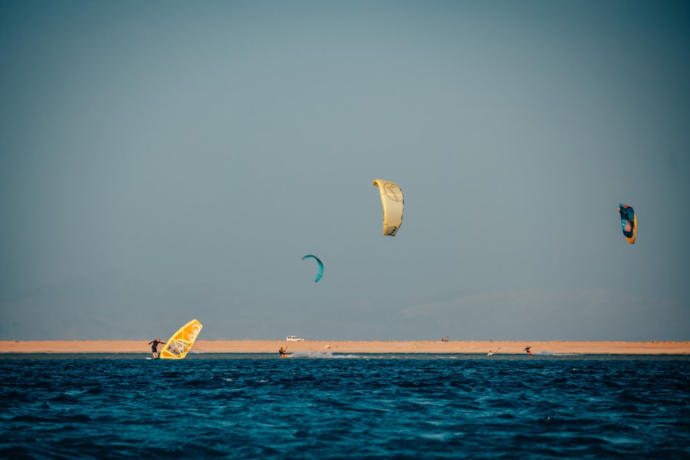 white and yellow kite surfing on sea during daytime