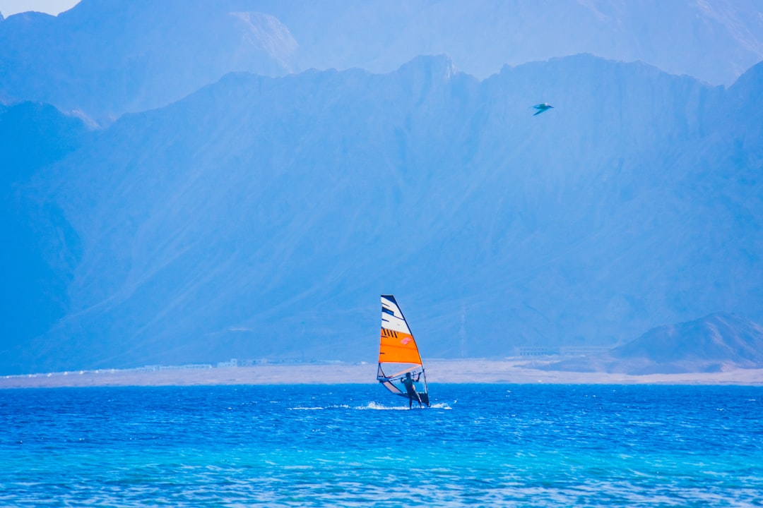 person riding on sail boat on sea during daytime