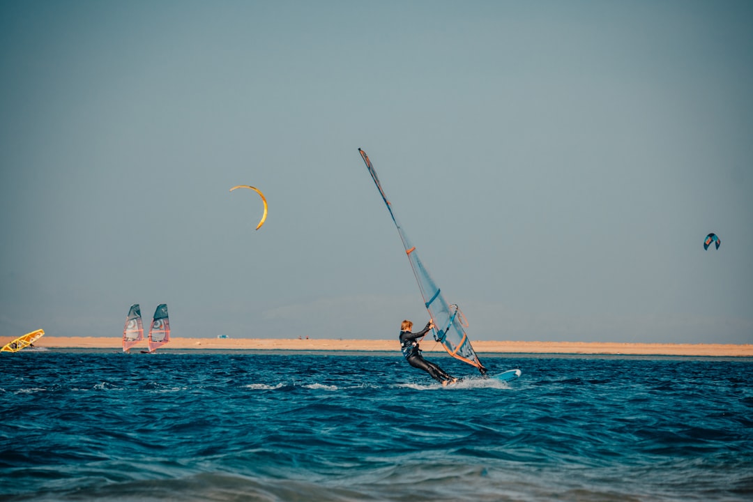 person in black shirt and black shorts riding on boat on sea during daytime