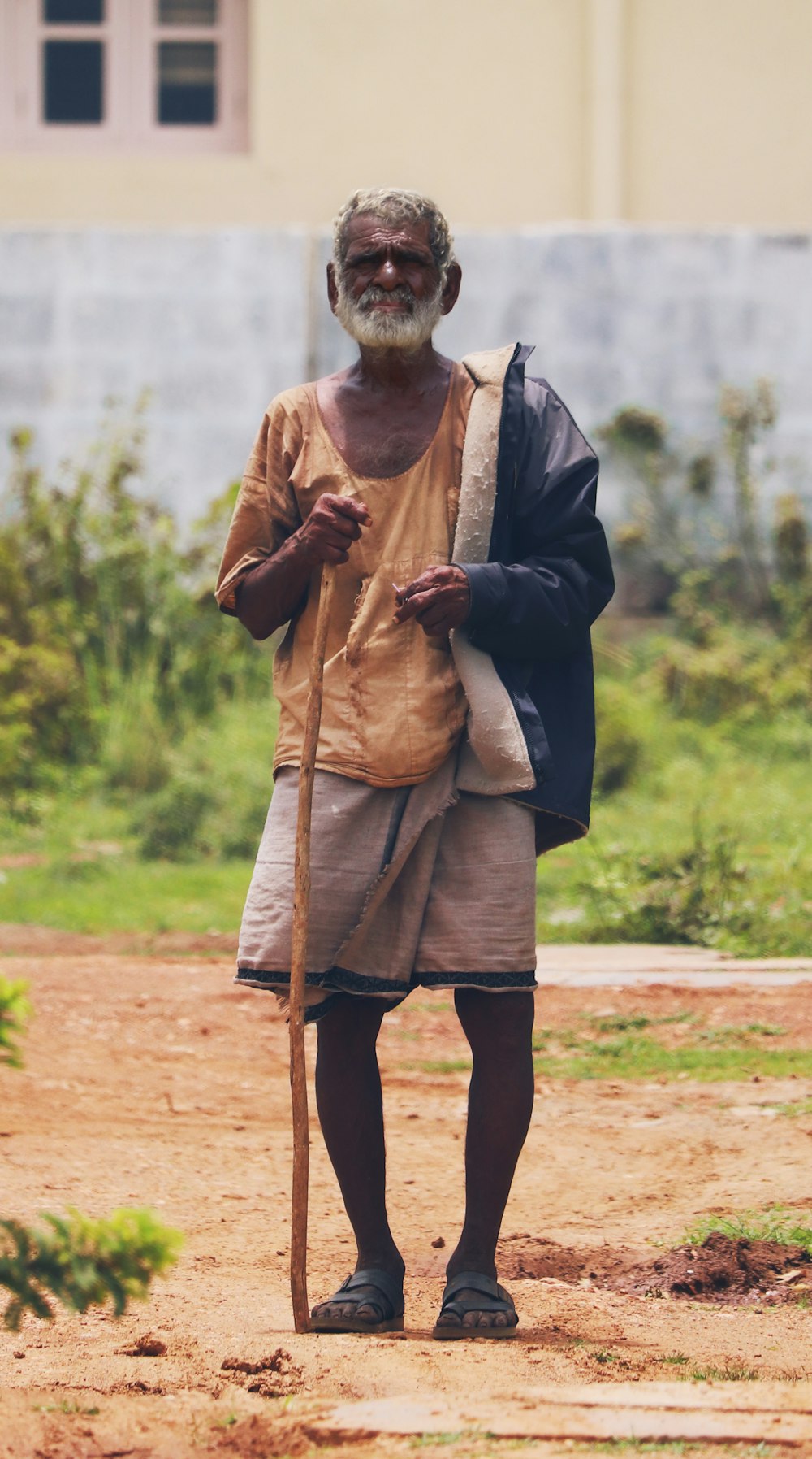 man in black coat standing on brown field during daytime