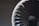 A close-up image of a fan blade assembly, likely from a turbine or a model jet engine. The blades are arranged in a circular pattern, with a combination of black and white colors. The background is blurred, focusing attention on the detailed texture and geometric design of the blades.
