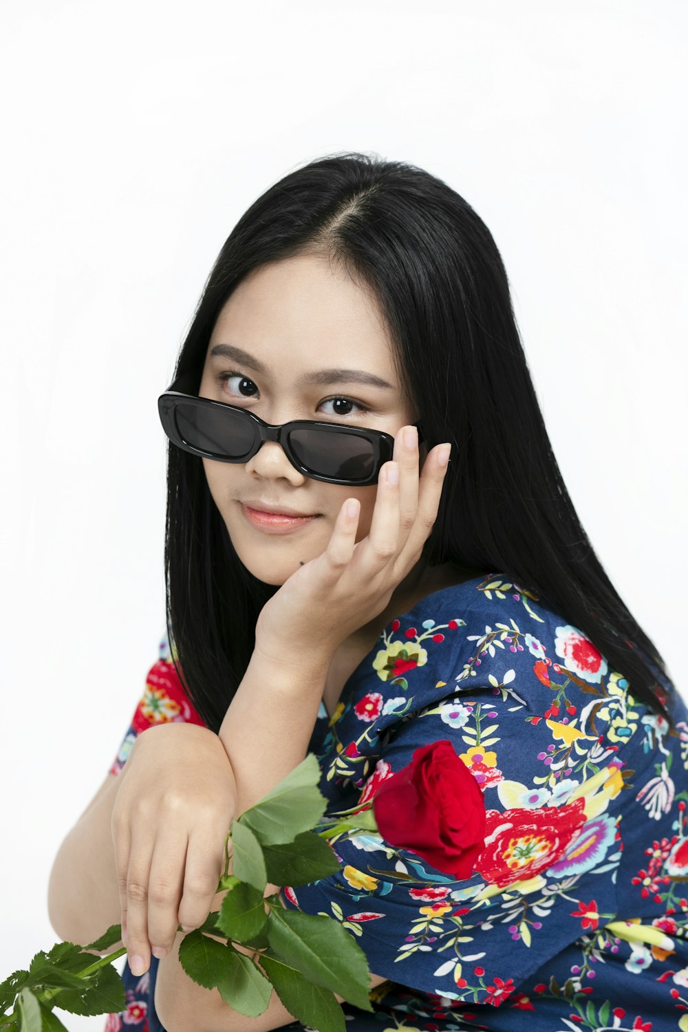 woman in green red and yellow floral shirt wearing black sunglasses