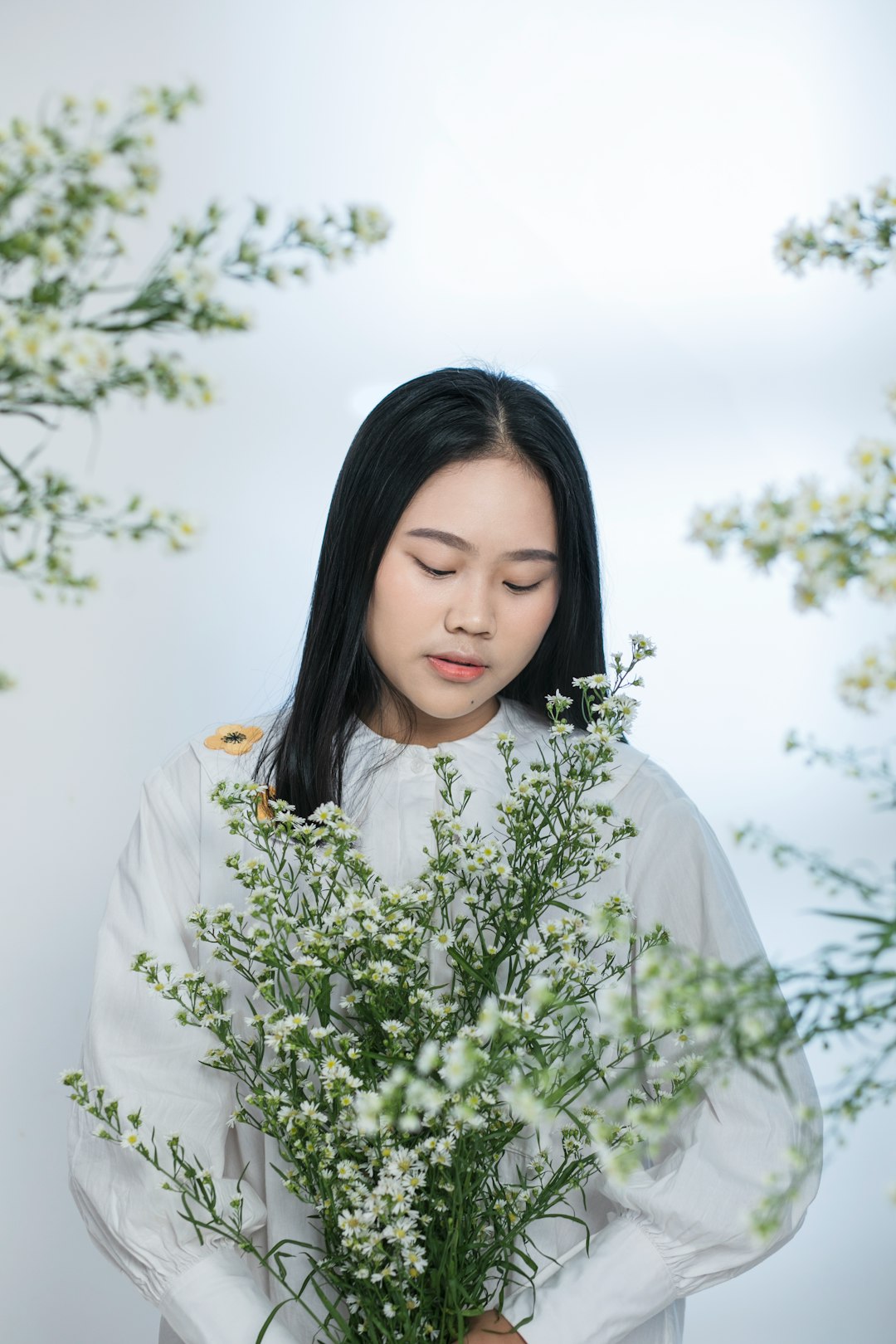 woman in white dress shirt standing beside green plant during daytime