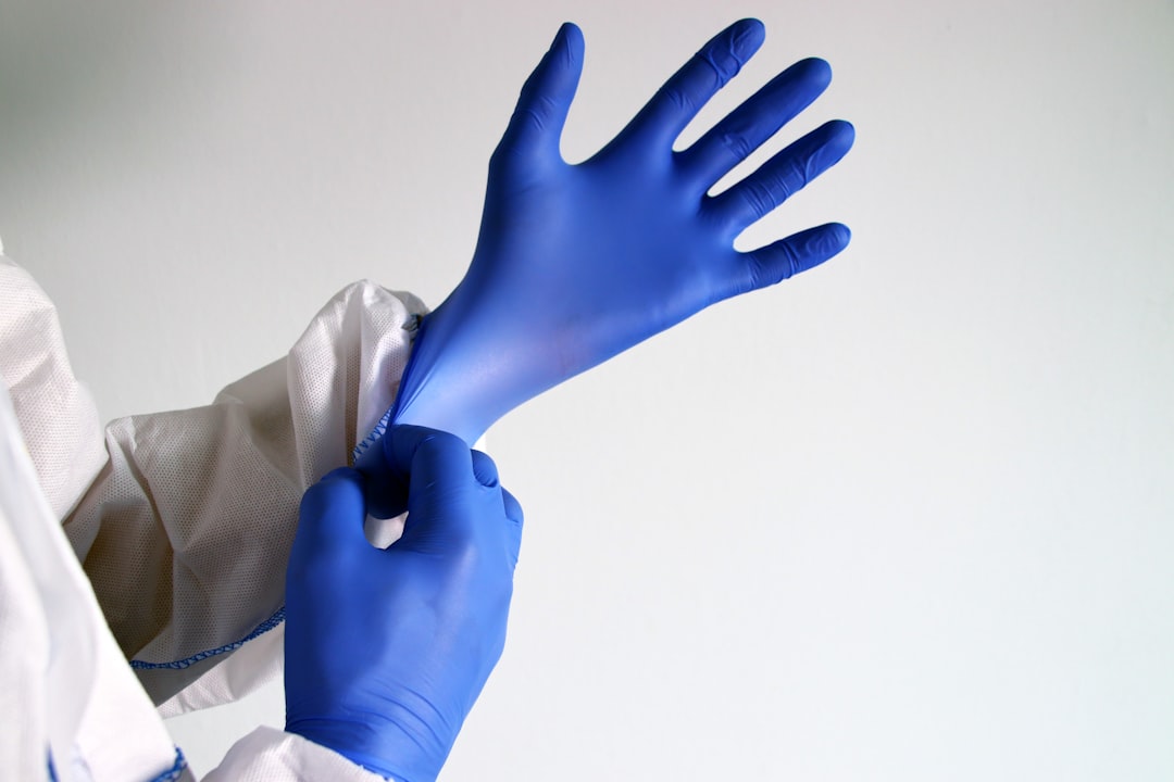 person in white long sleeve shirt, medical staff putting on nitrile gloves