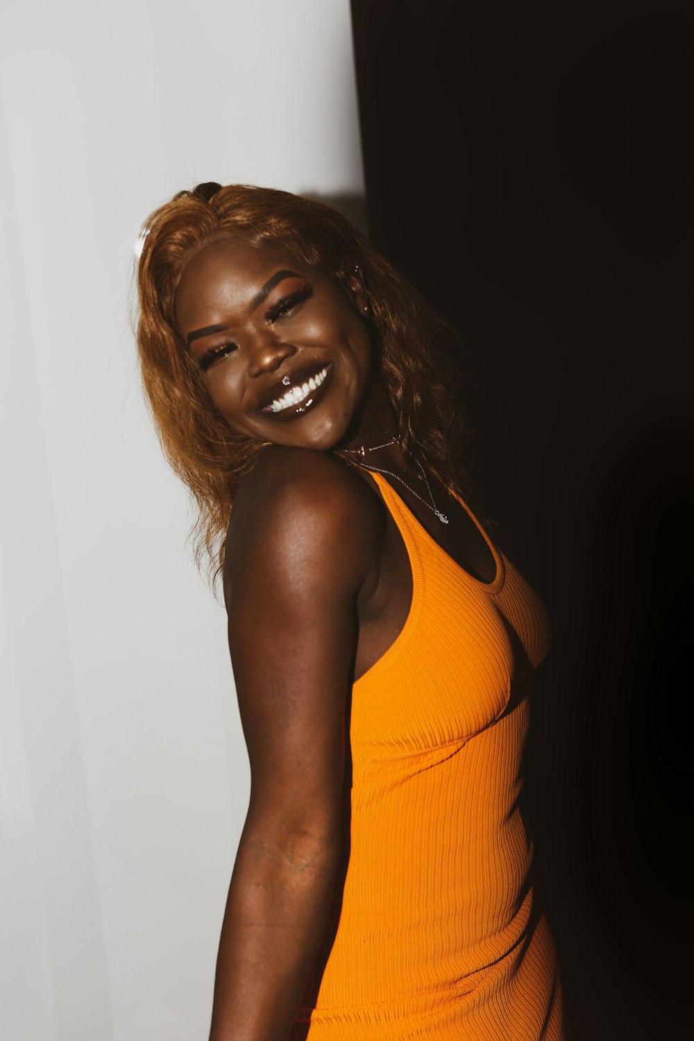 woman in orange tank top smiling