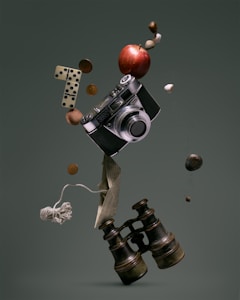 A surreal arrangement of various objects is floating in mid-air against a muted green background. The central focus is a vintage camera surrounded by a red apple, a pair of domino tiles, coins, a paper boat made from printed text, a ball of string, and a pair of old binoculars. Small pebbles and a couple of nuts appear to be suspended along with these items.