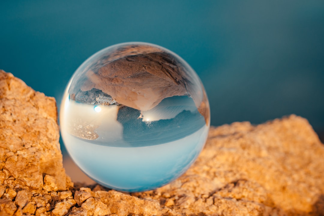 clear glass ball on brown sand