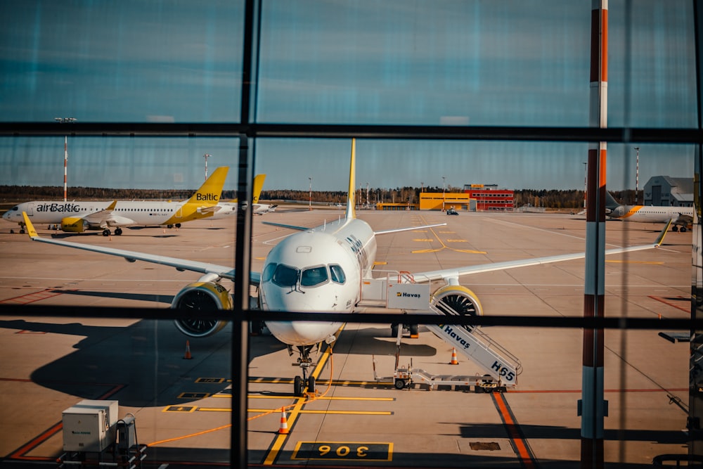 white and blue airplane on airport during daytime