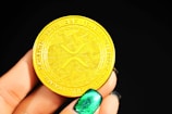 gold round coin on persons hand
