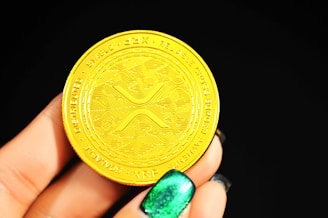 gold round coin on persons hand