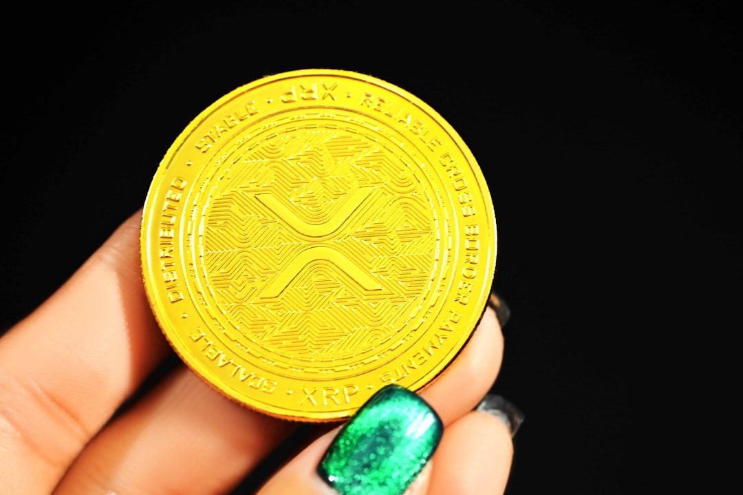 A lady with beautiful hand is holding a XRP gold