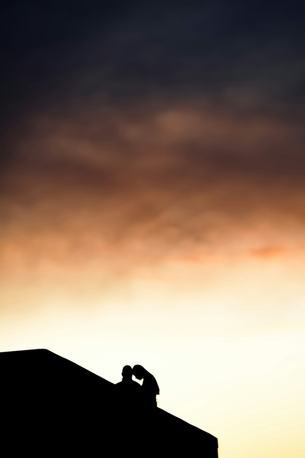 silhouette of house under orange sky