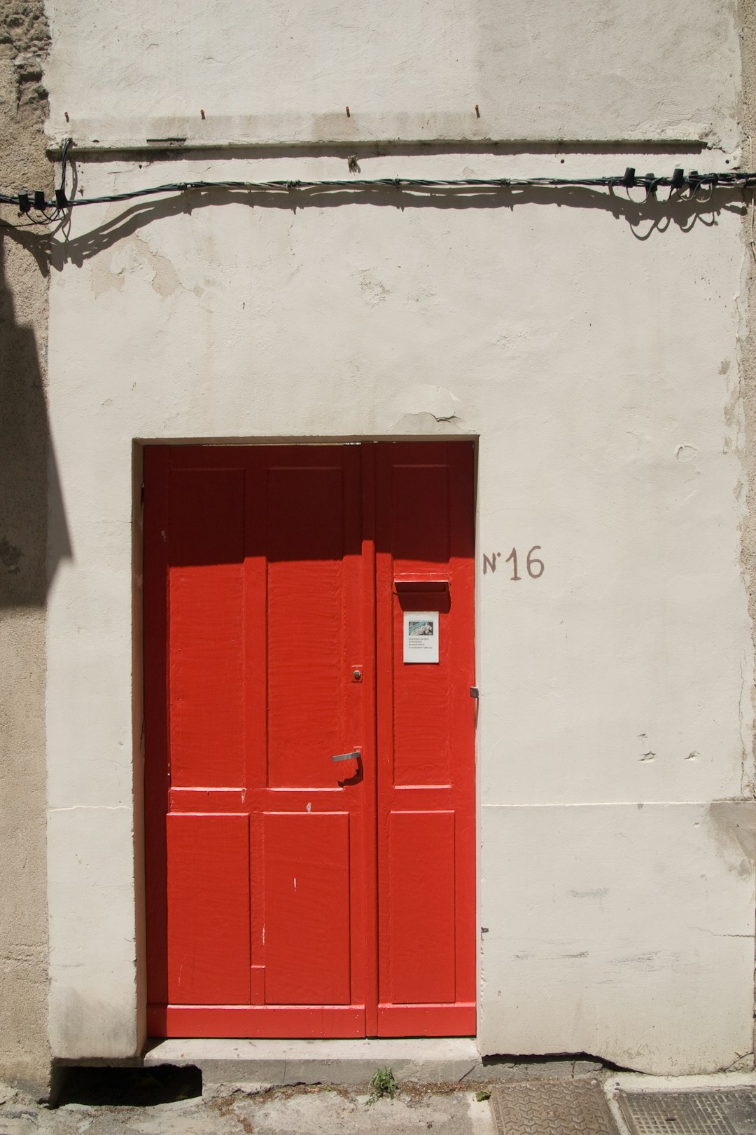 red wooden door on white concrete wall